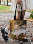 Person holding a tote bag with a Degas Two Dancers painting design on a leafy street.