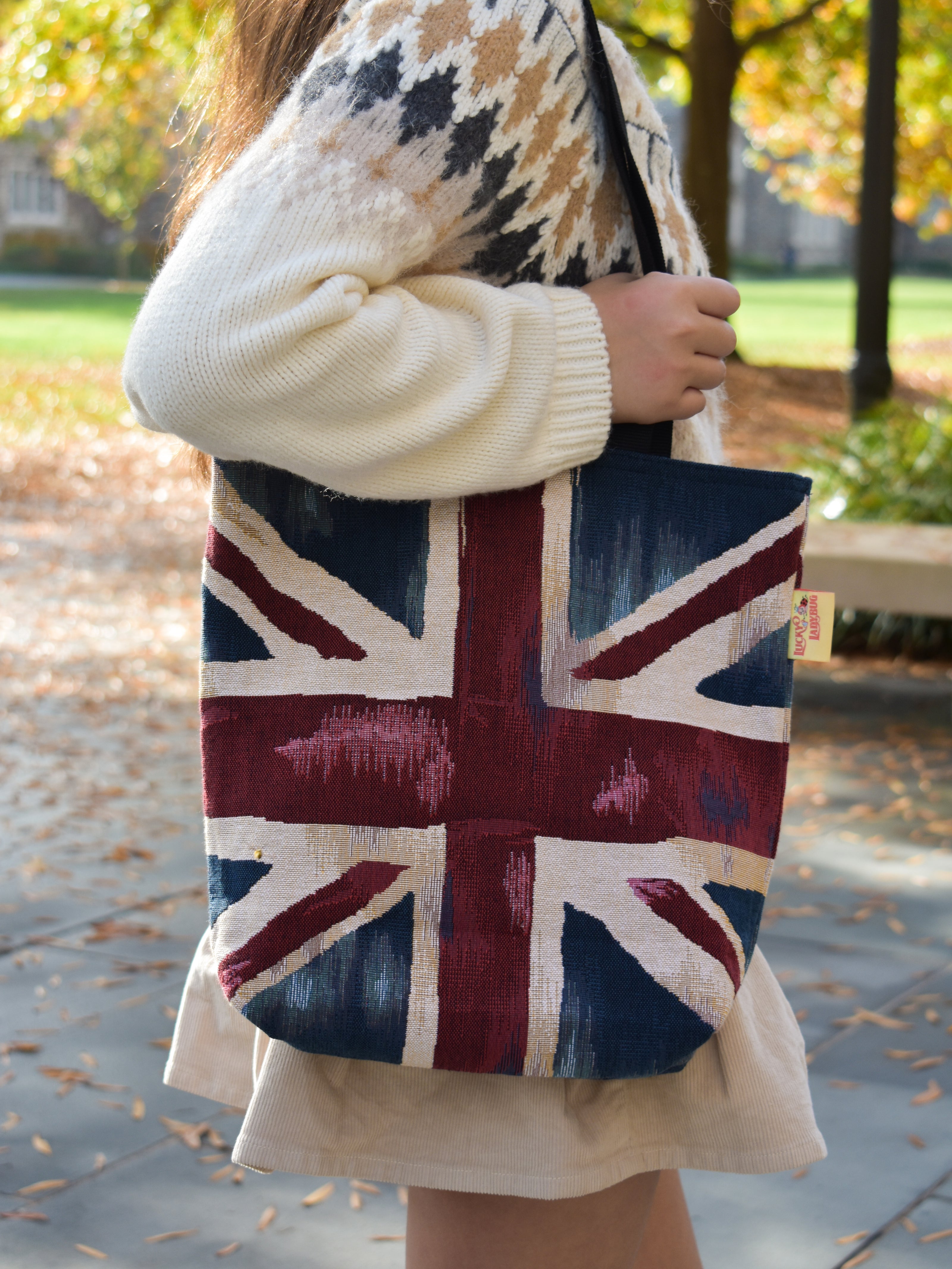 Person holding a tote bag with a Union Jack design outdoors. Union Jack Britain London England Aesthetic Europe Tote Bag