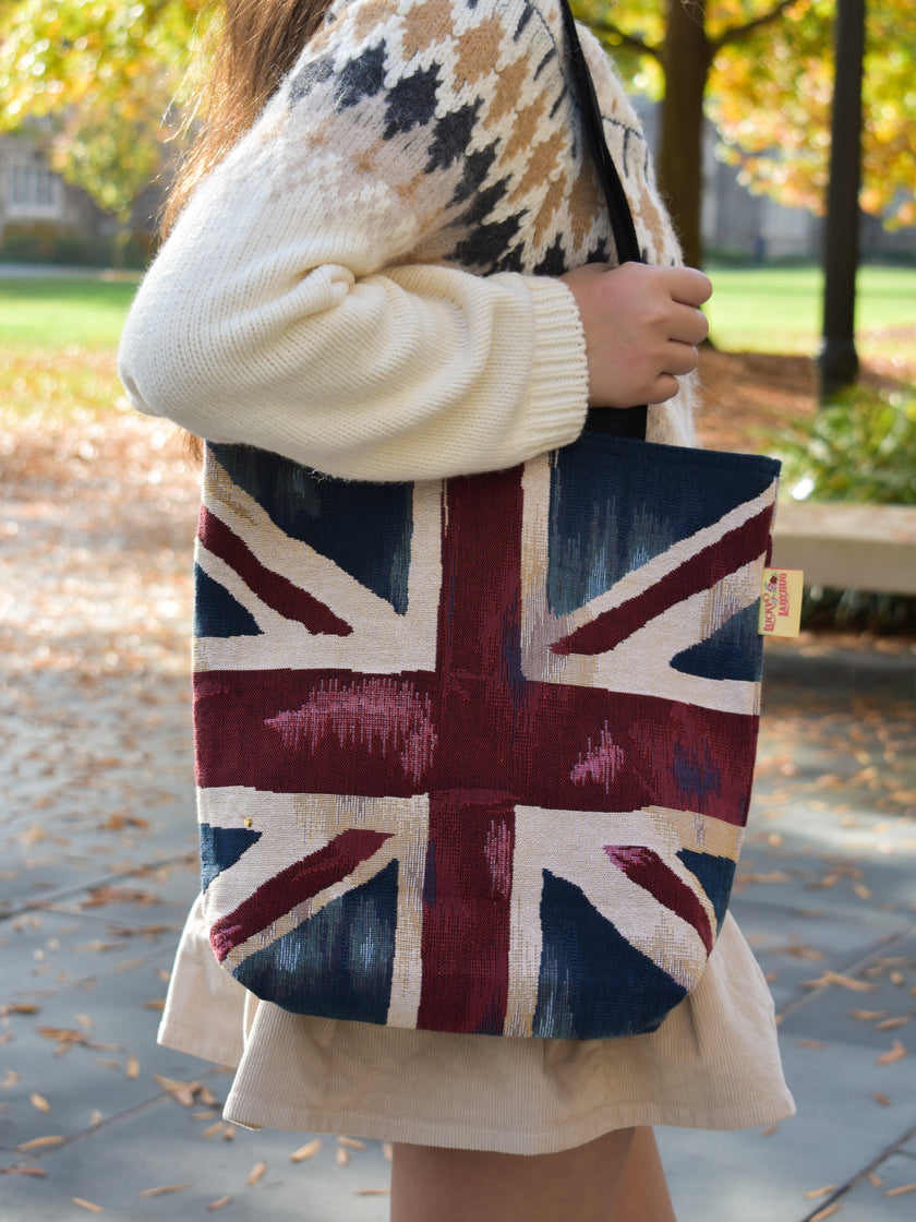 Person holding a tote bag with a Union Jack design outdoors. Union Jack Britain London England Aesthetic Europe Tote Bag