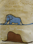 Embroidered design of an elephant and a starry background with text on fabric.